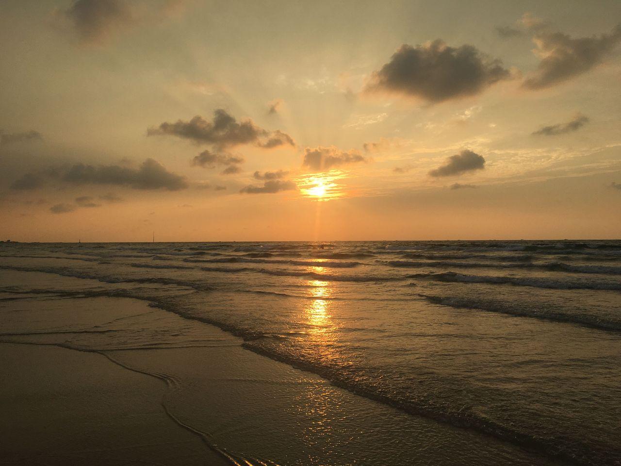Gwakji Beach in Jeju Island during sunset with soft golden light reflecting on the water and sand.